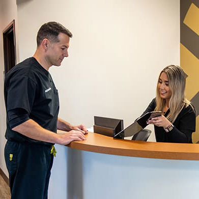 Doctor talking to receptionist at front desk